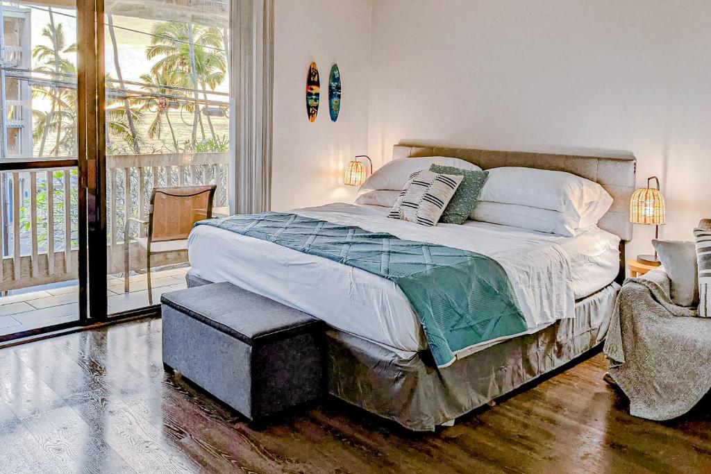 a bedroom with a large bed and a balcony at Kona Bali Kai 264 in Kailua-Kona
