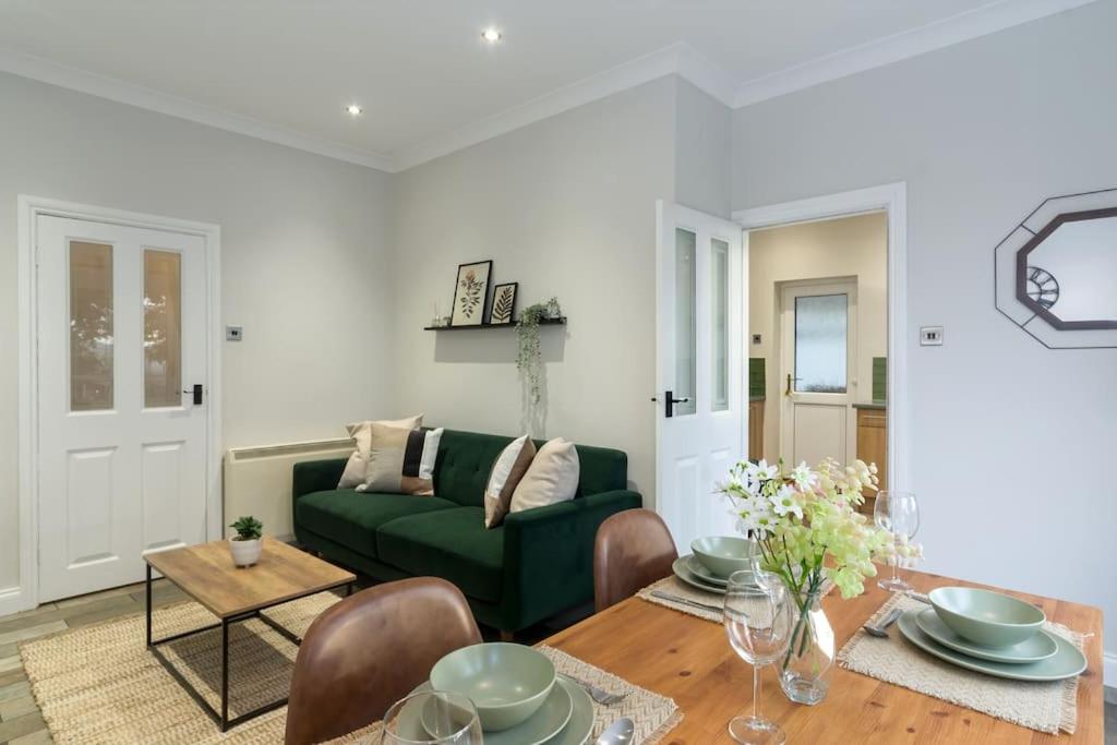 sala de estar con sofá verde y mesa en Elegant three bed bungalow en Lincolnshire