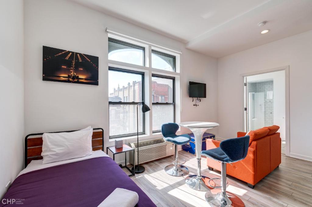 a bedroom with a bed and two chairs and a couch at Chicago Second Floor Studio by 747 Lofts in Chicago