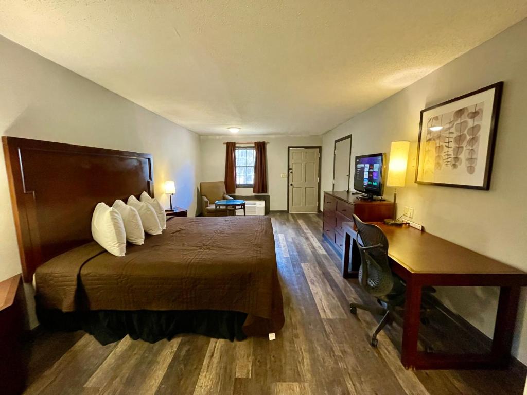 Pokój hotelowy z łóżkiem i biurkiem w obiekcie Alpine Village Inn w mieście Helen