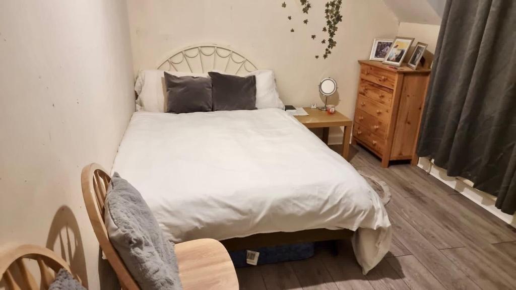 a bedroom with a white bed and a wooden table at Centrally located Double Bedroom in Leeds in Hunslet