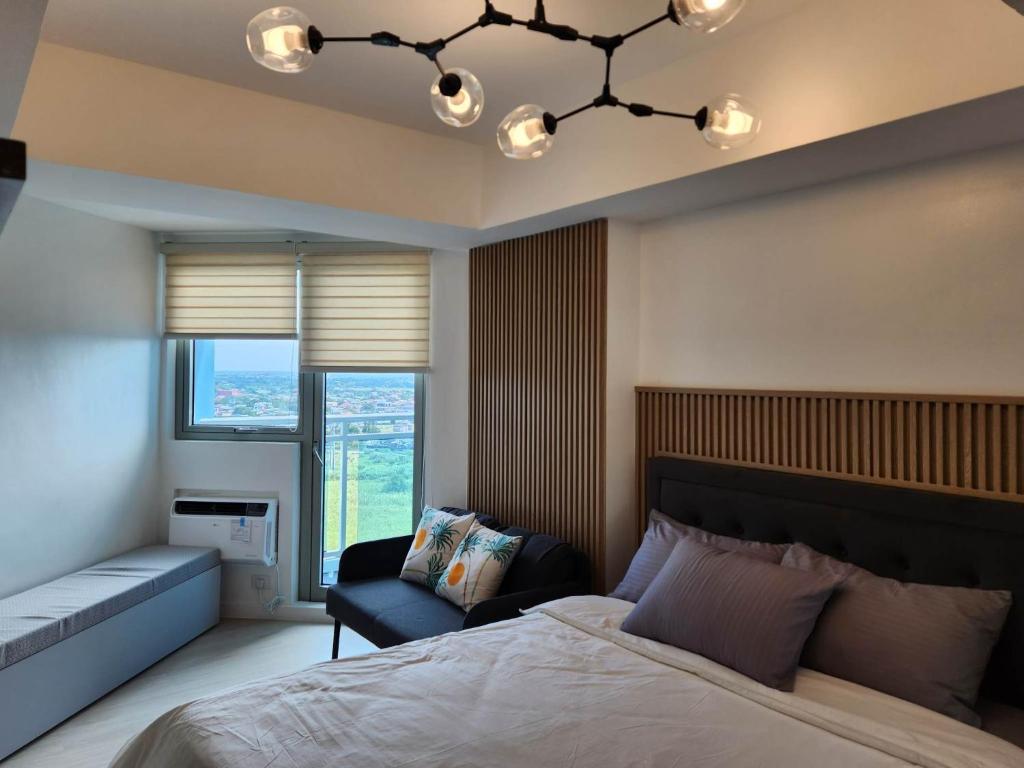 - une chambre avec un lit, une chaise et un lustre dans l'établissement Hotel type Studio in Azure, à San Fernando