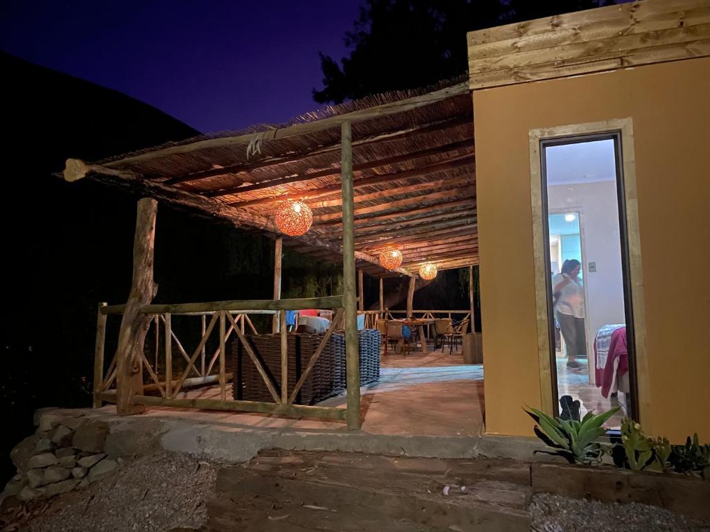 eine Person, die nachts auf einer Terrasse steht in der Unterkunft Cabaña en valle del elqui Horcon in Pisco Elqui