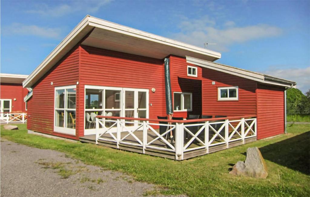 グドイェムにある2 Bedroom Stunning Home In Gudhjemの芝生の大きなポーチのある赤い家