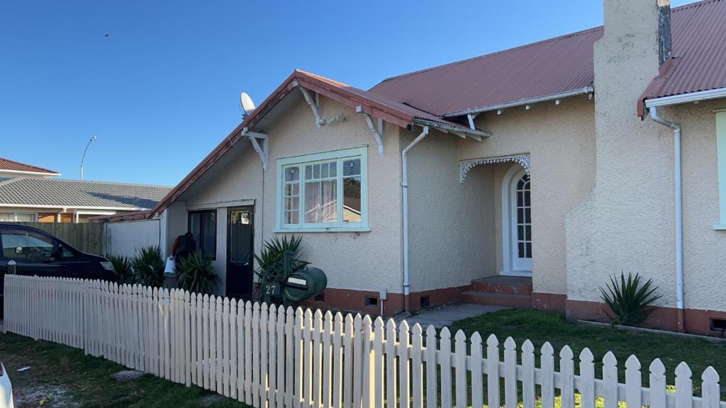 a white picket fence in front of a house at Young Hostel in Rotorua