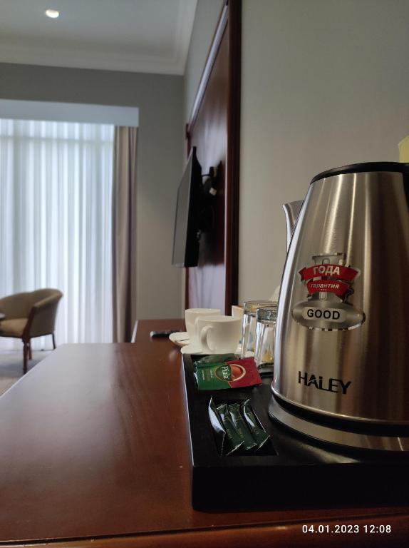a coffee maker sitting on top of a table at Mir Luxe Plaza in Tashkent