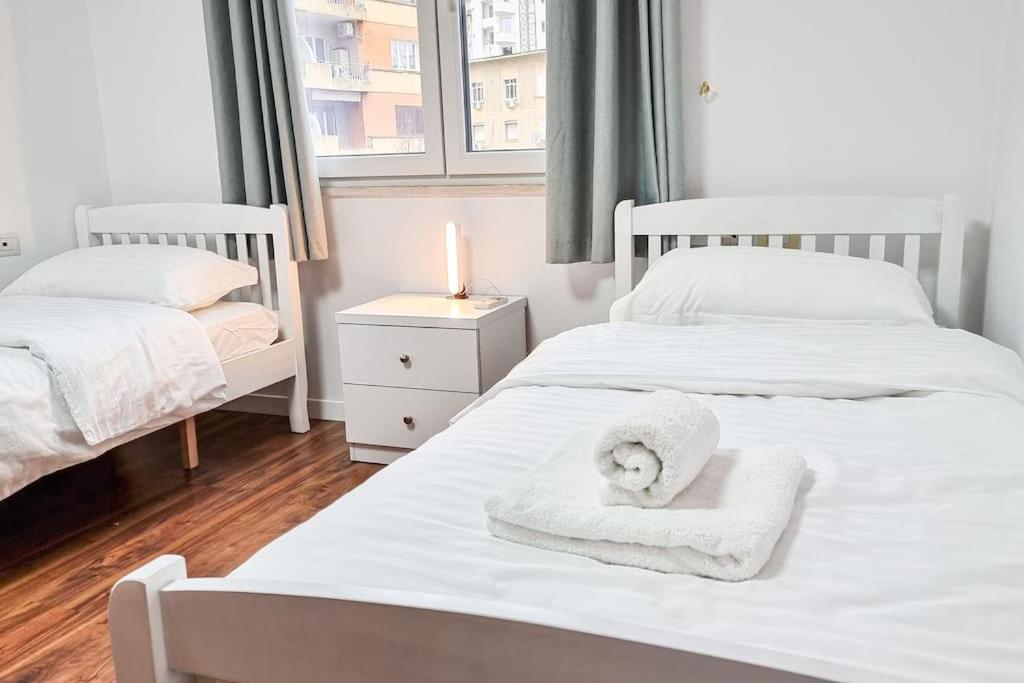 - 2 lits avec serviettes dans une chambre dans l'établissement City Center 2BR Apartment, à Tirana