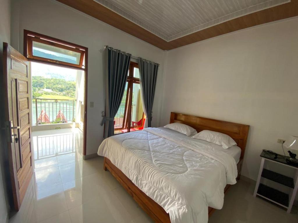 - une chambre avec un lit et une fenêtre dans l'établissement Tama View, à Tuk Tuk
