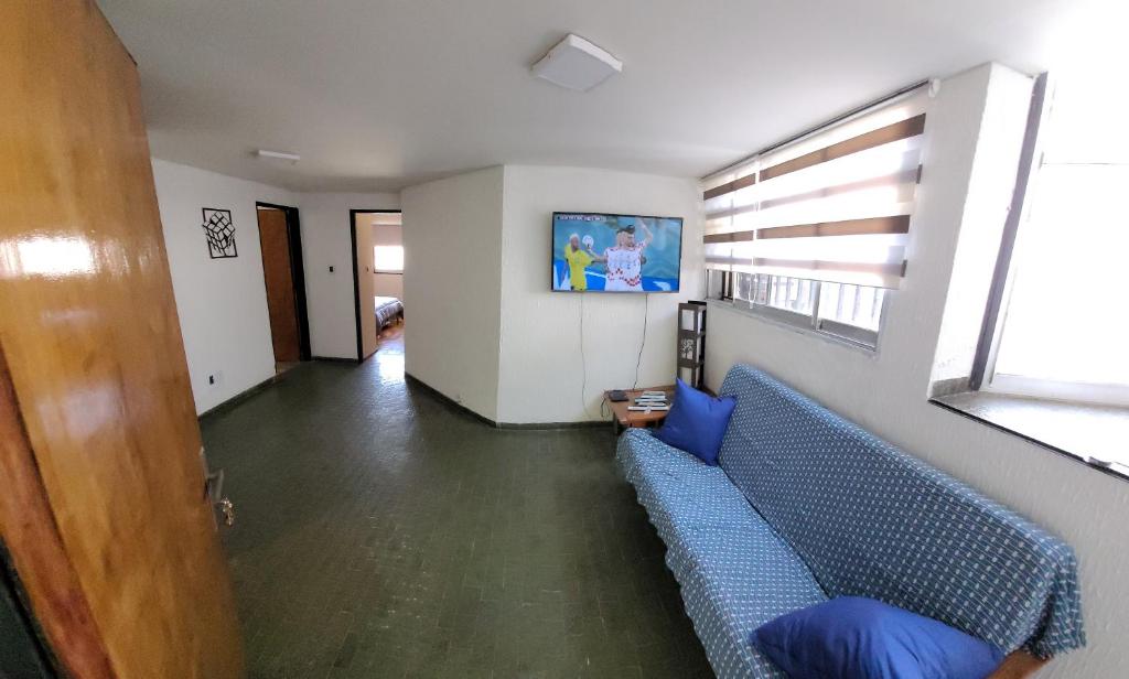 Departamento en el centro de Mendoza في ميندوزا: غرفة معيشة مع أريكة زرقاء ونافذة