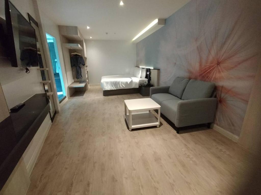 ein Wohnzimmer mit einem Sofa und einem Bett in der Unterkunft Karnyapha Hotspring hotel in Ban Lum Than