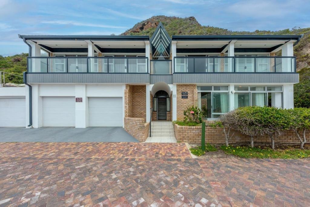 a large house with a balcony and a driveway at Vic Bay Beach House in Victoria Bay