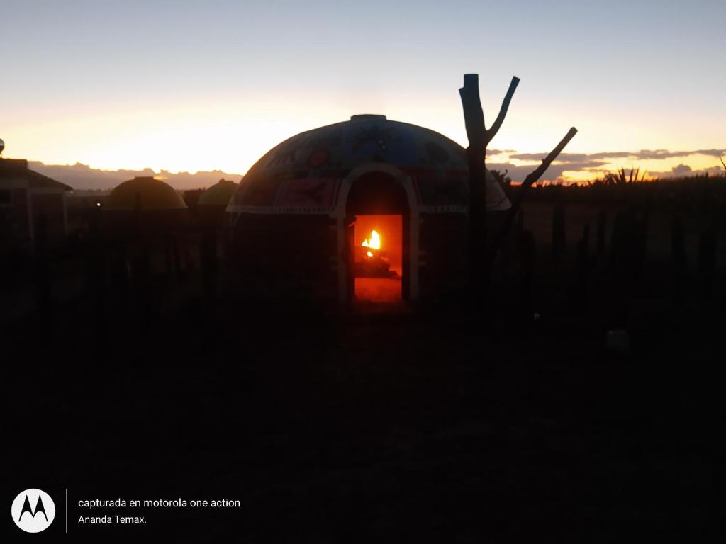 an igloo house with a fire in it at sunset at Glamping temax 