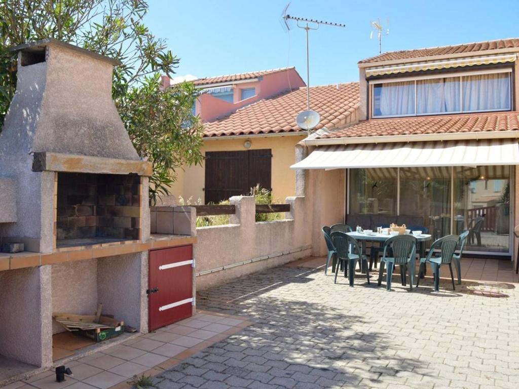 d'une terrasse avec une table et un four. dans l'établissement Maison 5 pièces, 8 couchages, terrasse, proche plage et commerces - Saint Pierre La Mer - FR-1-229D-240, à Saint Pierre La Mer