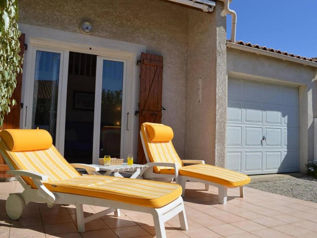 2 chaises et une table sur une terrasse avec garage dans l'établissement Pavillon climatisé 6 couchages, terrasse, garage, à 750m de la plage - St Pierre la Mer - FR-1-229D-379, à Saint Pierre La Mer