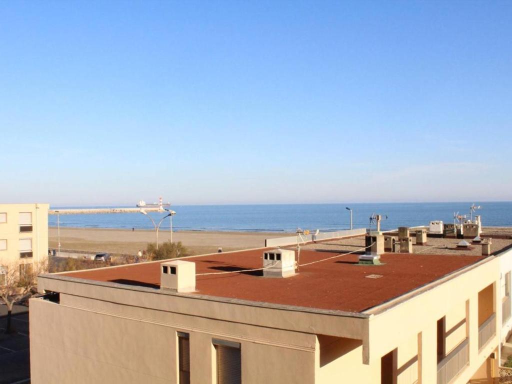 une vue d'un bâtiment avec l'océan en arrière-plan dans l'établissement Appart 6 pers, 50m plage, balcon, parking, animaux admis - FR-1-229C-338, à Port-la-Nouvelle
