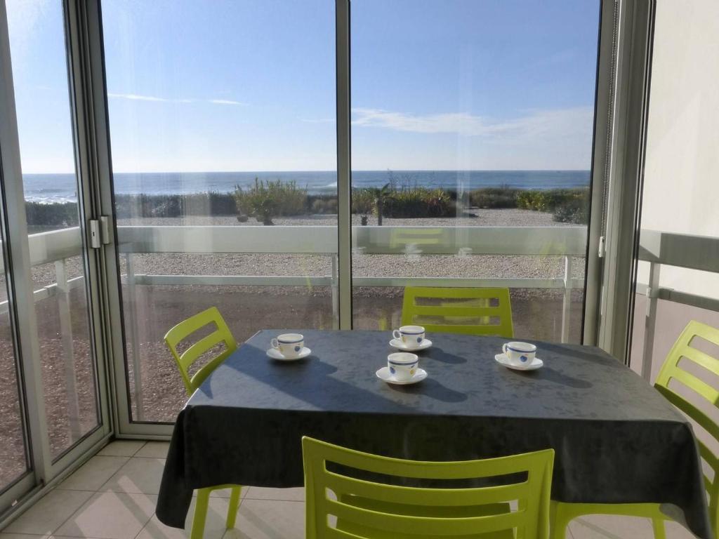 une table et des chaises dans une pièce avec vue sur l'océan dans l'établissement Appartement 2 pièces 6 couchages avec balcon fermé à Saint-Gilles-Croix-de-Vie - FR-1-224-307, à Saint-Gilles-Croix-de-Vie