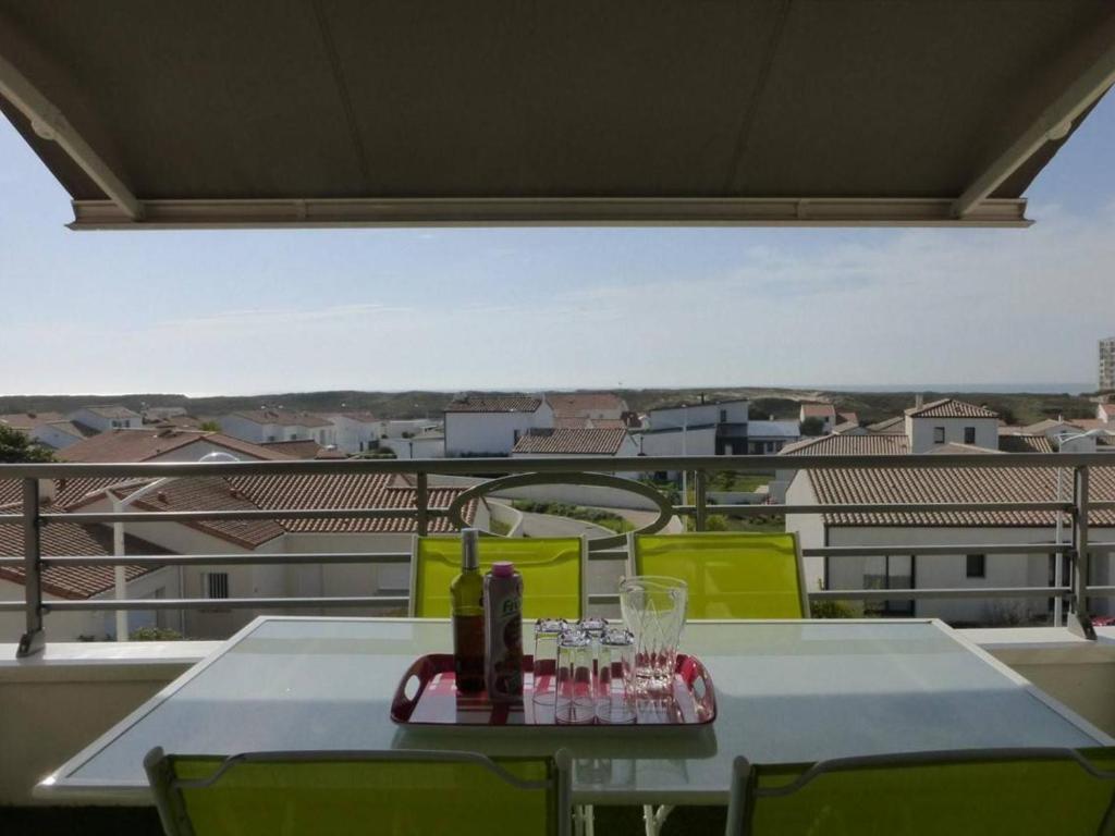 - une table avec des bouteilles et des verres sur un balcon dans l'établissement Appartement 2 pièces avec balcon, parking et proche plage à Saint-Gilles-Croix-de-Vie - FR-1-224-587, à Saint-Gilles-Croix-de-Vie