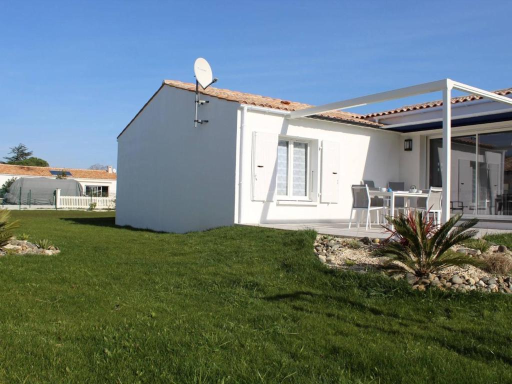 a white house with a table and chairs in a yard at Maison Saint-Pierre-d'Oléron, 4 pièces, 5 personnes - FR-1-246A-12 in Saint-Pierre-dʼOléron