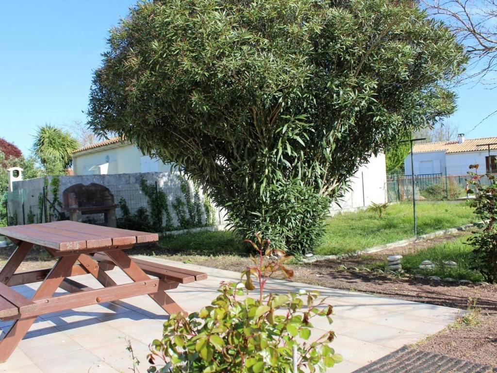 - une table de pique-nique en bois à côté d'un arbre dans l'établissement Maison calme avec jardin clos, à proximité de la plage et des pistes cyclables, 4 couchages - FR-1-246A-376, à Foulerot