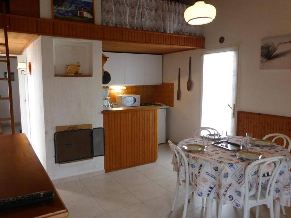 eine Küche und ein Esszimmer mit einem Tisch und Stühlen in der Unterkunft Maison Bretignolles-sur-Mer, 2 pièces, 4 personnes - FR-1-224A-586 in Brétignolles-sur-Mer