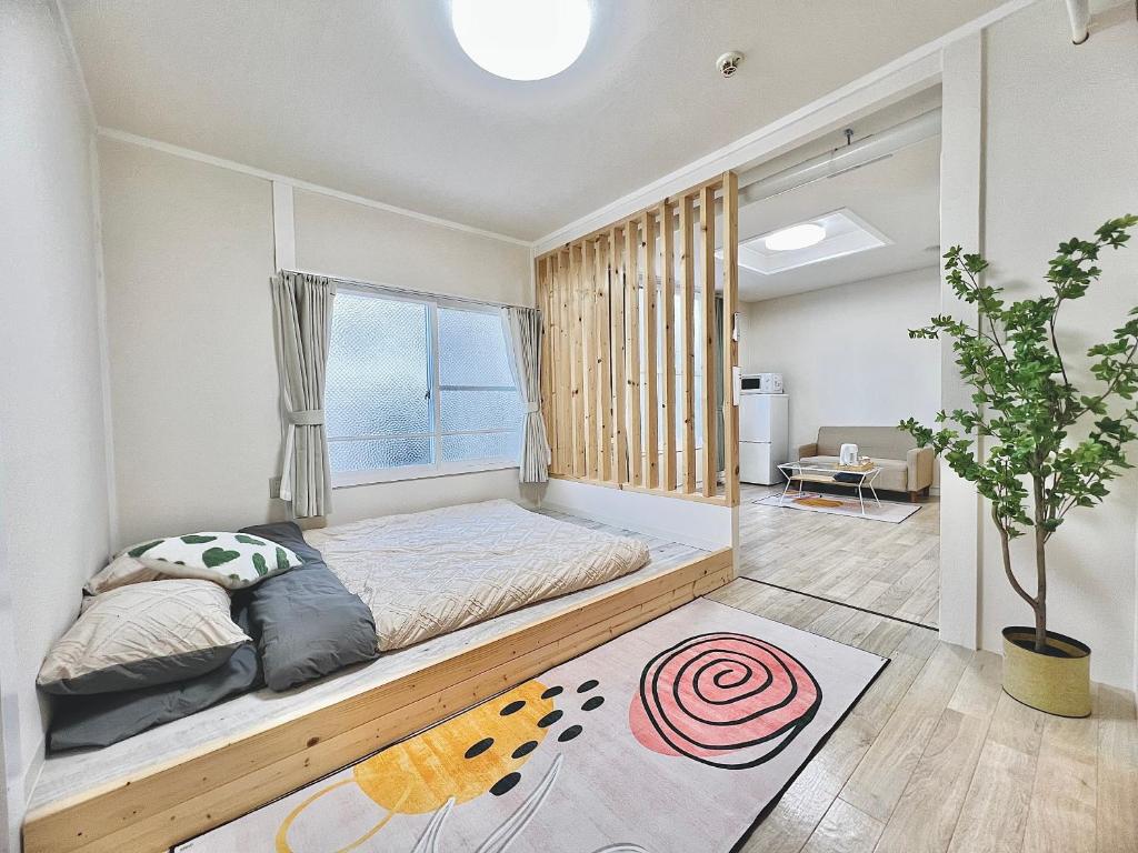 1 dormitorio con cama y ventana en attomi hostel, en Sapporo