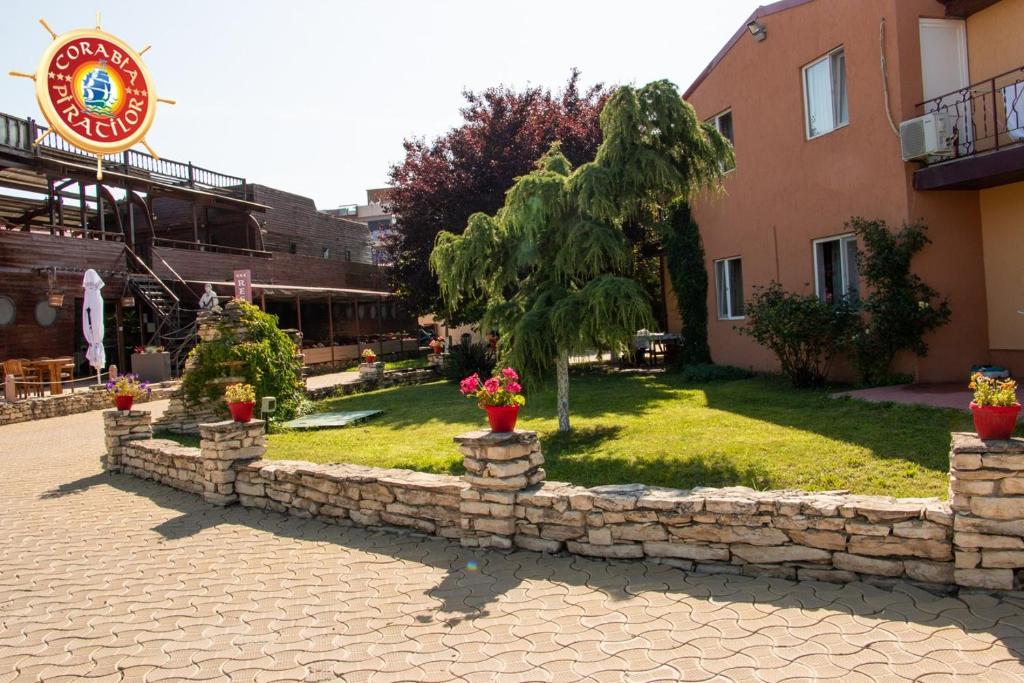 a stone wall in front of a building with plants at Club de Vacanta Corabia Piratilor-Mamaia Nord in Mamaia Sat/Năvodari