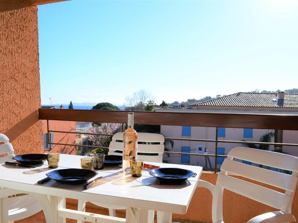 une table blanche et des chaises sur un balcon dans l'établissement Studio coin nuit 4 pers, parking, animaux admis, proche plage - Le Lavandou - FR-1-251-230, au Lavandou