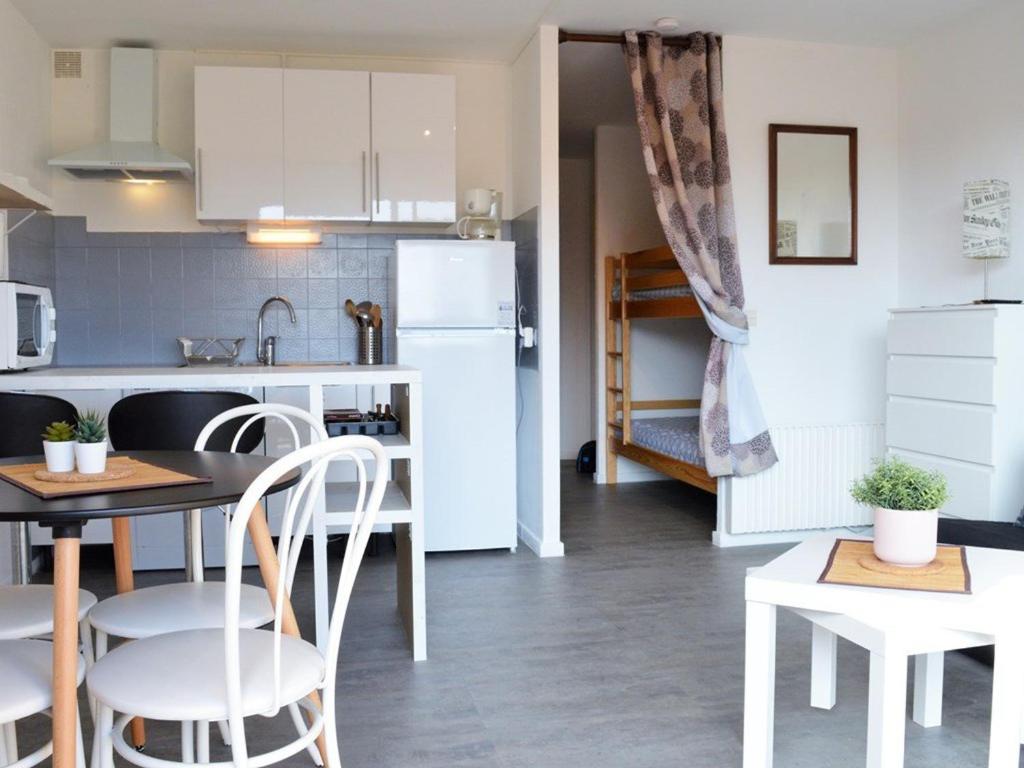 een keuken met een tafel en stoelen en een koelkast bij Appartement Le Lavandou, 1 pièce, 4 personnes - FR-1-251-240 in Le Lavandou