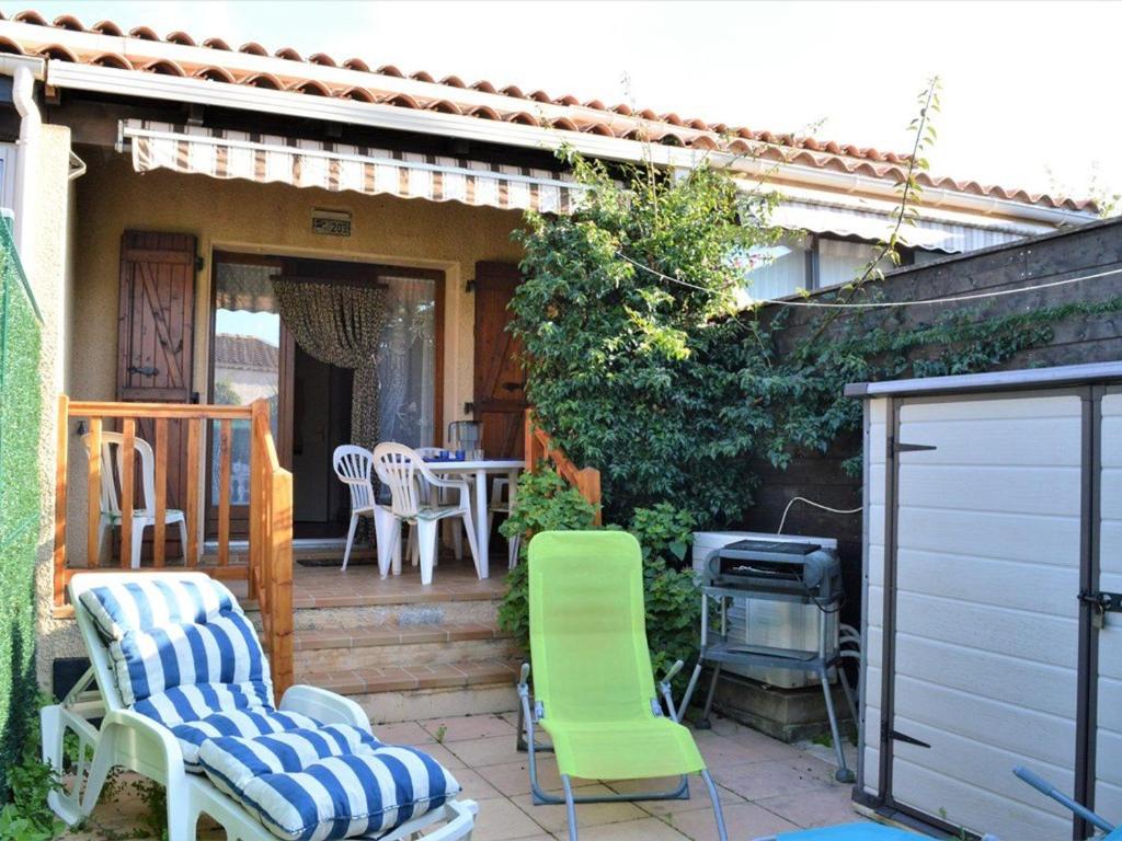 un patio avec des chaises, une table et un grill dans l'établissement Maison 2 pièces mezzanine, 6 couchages, piscine, tennis, proche plage - Bormes-les-Mimosas - FR-1-251-273, à Bormes-les-Mimosas