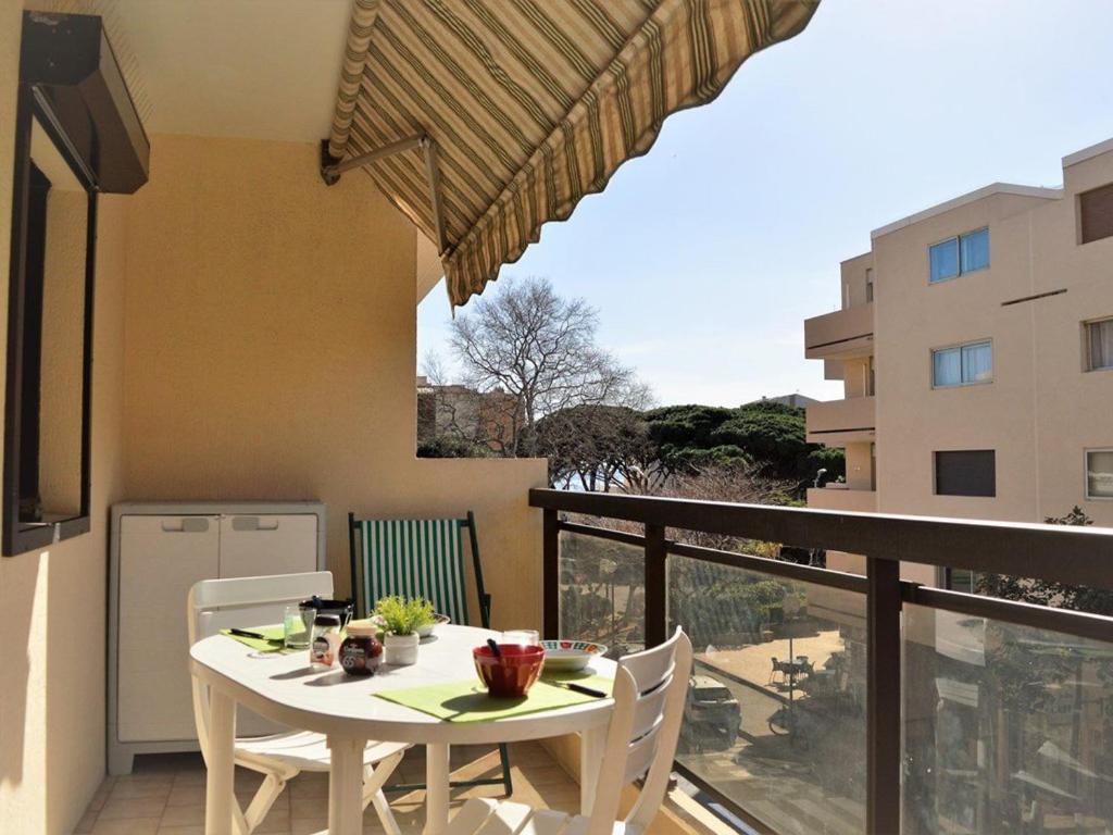 une table blanche et des chaises sur un balcon avec vue dans l'établissement Appartement climatisé avec balcon et parking privatif, à 100m de la plage - Le Lavandou - FR-1-251-352, au Lavandou