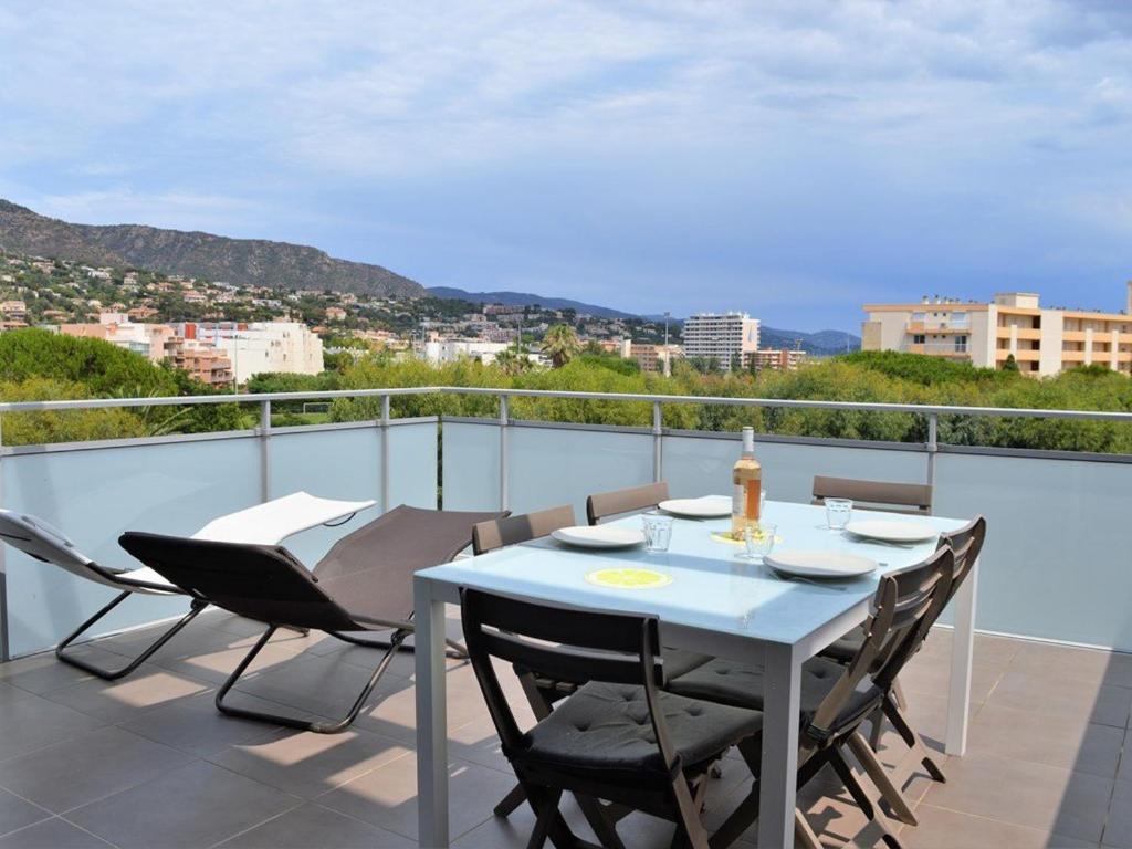 une table et des chaises sur un balcon avec vue dans l'établissement Appartement moderne avec terrasse, parking et proche plage au Lavandou - 2 étoiles - FR-1-251-331, au Lavandou