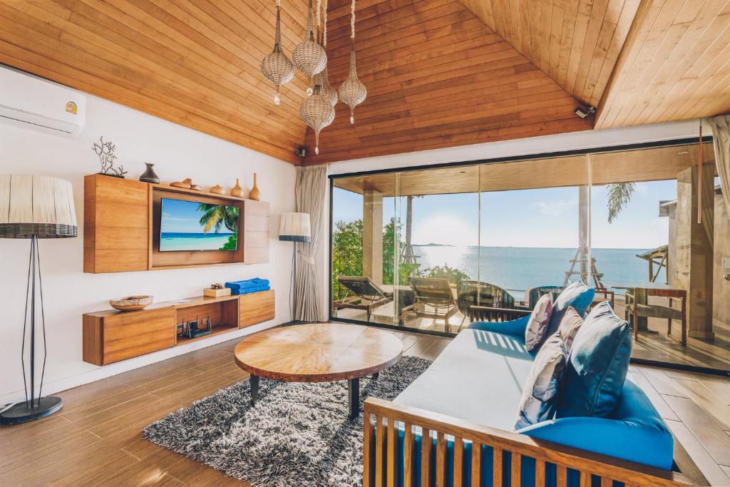 a living room with a blue couch and a table at Allure Resort in Choeng Mon Beach