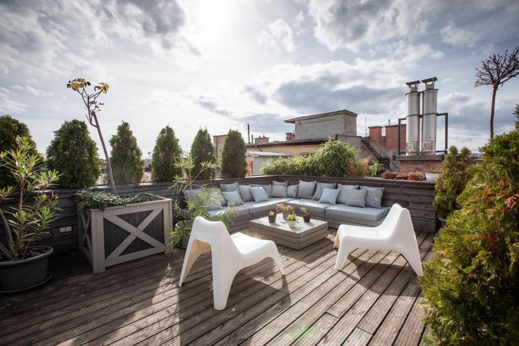 een terras met een bank en stoelen bij 205m2 Penthouse with 75m2 Castle View Terrace and Barbercue - My Loft in Budapest in Boedapest