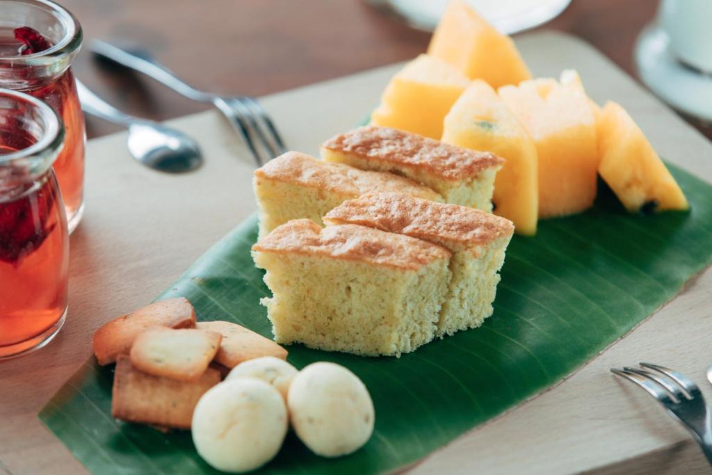 a green plate with cakes and fruit on a table at Adagio Shihtiping in Fengbin