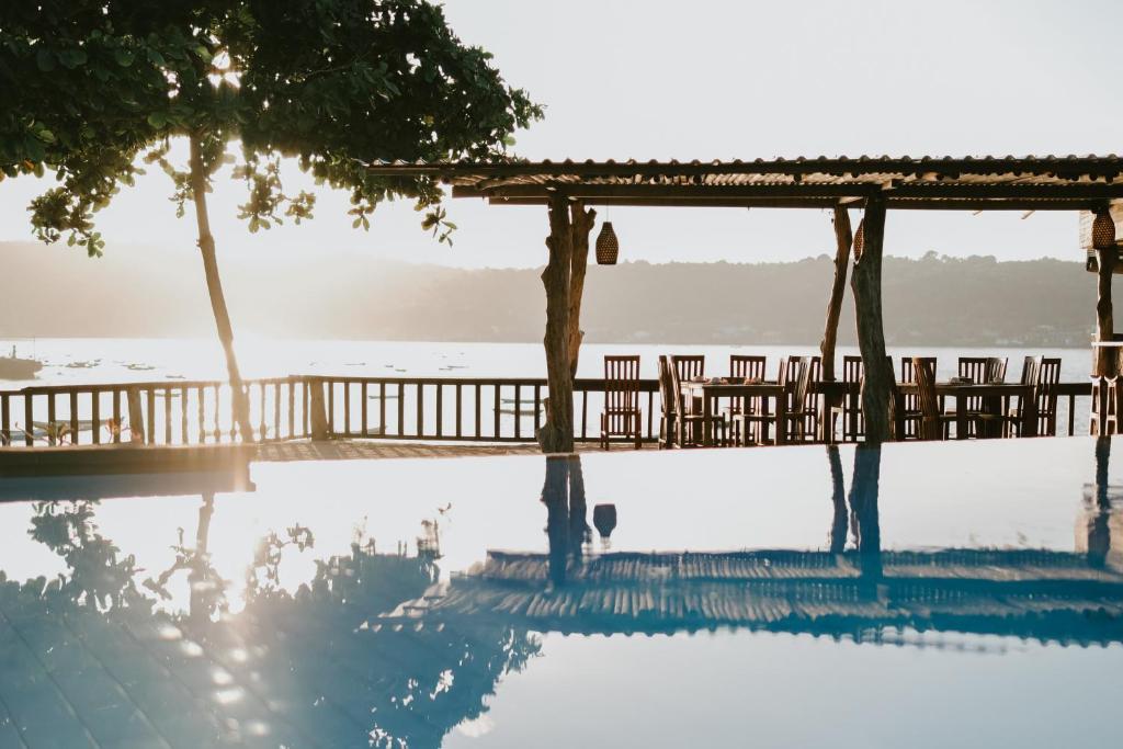 ein Pool mit einer Terrasse und einer Reflexion im Wasser in der Unterkunft Dini D'Nusa Lembongan in Nusa Lembongan