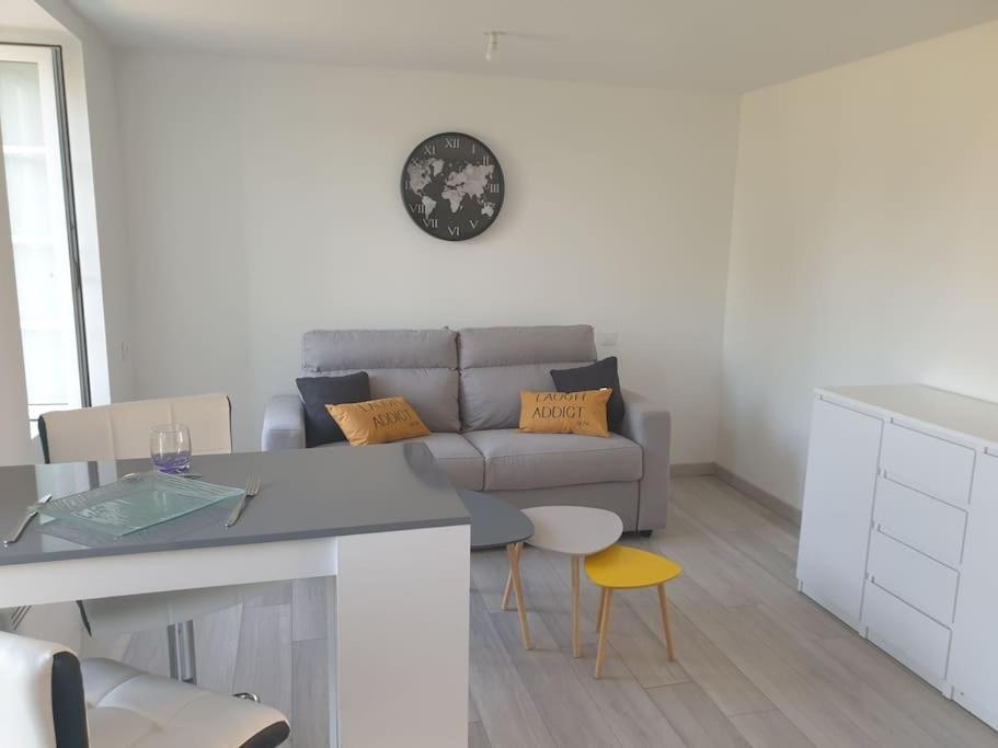 sala de estar con sofá y mesa en appartement meublé parking gratuit 2 nuits minimum, en Montaigu-Vendée