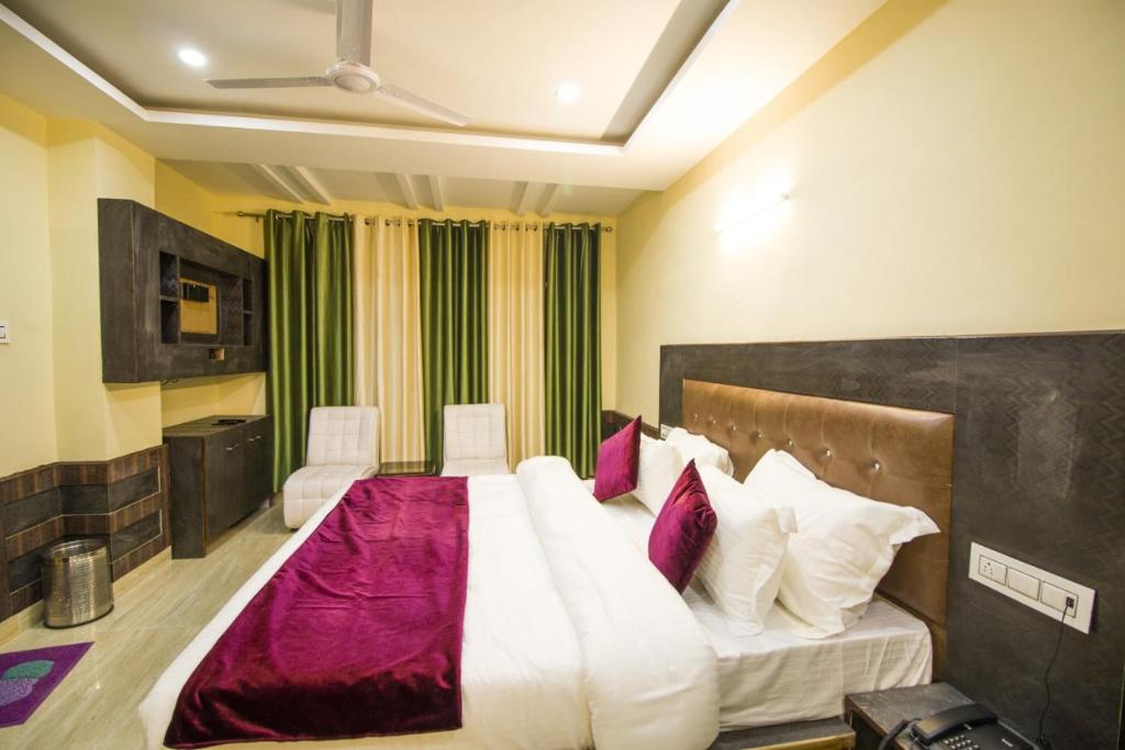 達蘭薩拉的住宿－Vella Mrina Group of Hotel Edge，卧室配有一张带白色和紫色枕头的大床