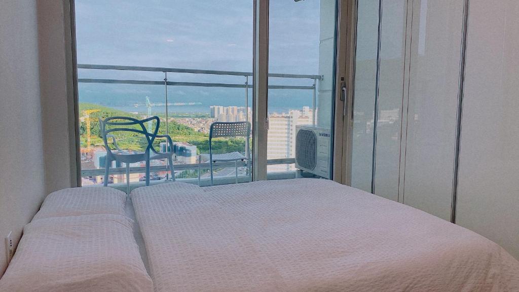 - une chambre avec un lit et une grande fenêtre dans l'établissement Shine residence, à Incheon