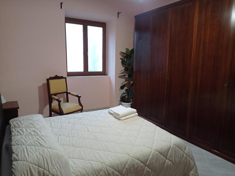 1 dormitorio con 1 cama grande y pared de madera en Casa dei Faggi, en Tolfa