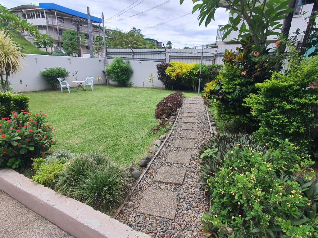 un patio trasero con césped y un jardín con plantas en Cosy 2 bedroom unit with pool,Wifi en Suva