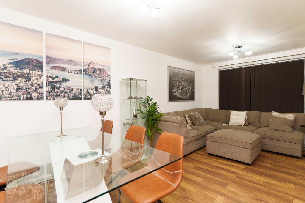 Una sala de estar con una mesa de cristal y un sofá. en West Park House, en Bramhope