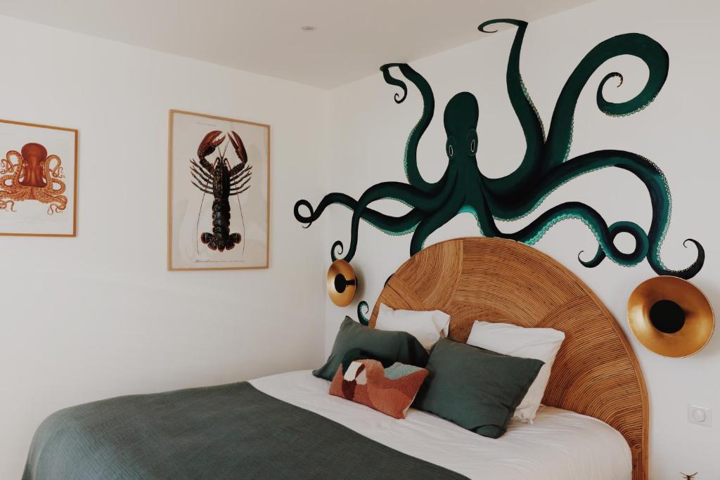 a bedroom with a bed with a wooden headboard at Le Rose Thé in La Ciotat