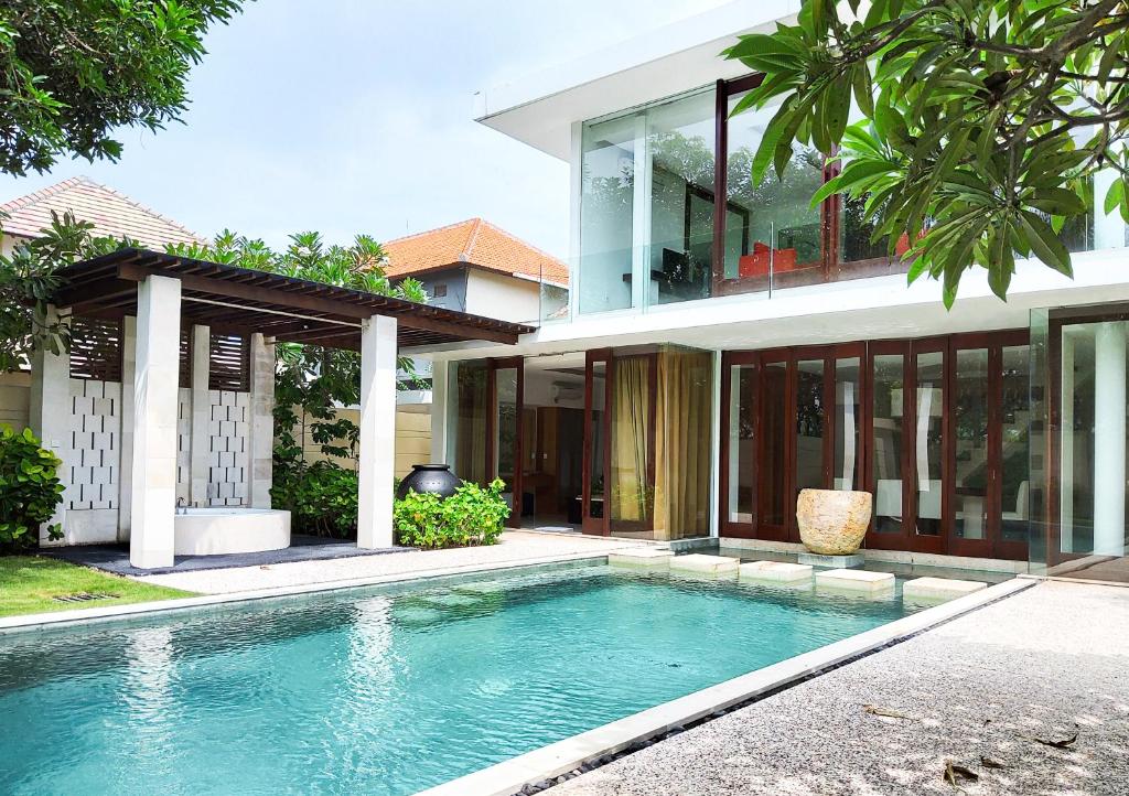 una casa con piscina di fronte a una casa di The Wangsa Benoa a Nusa Dua