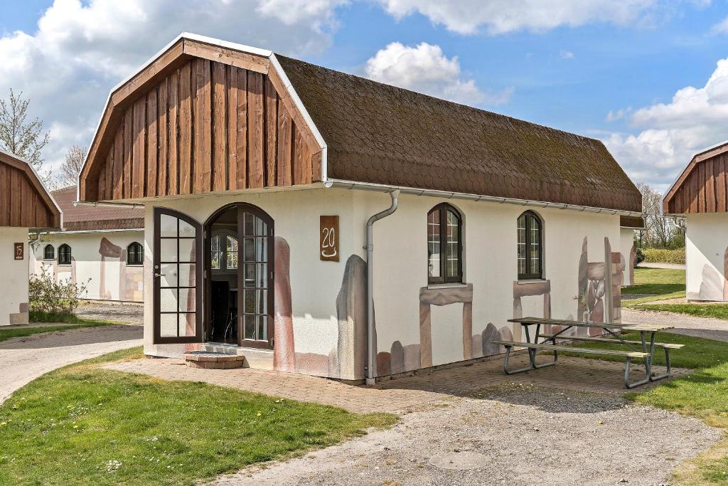 un piccolo edificio bianco con tetto in legno di First Camp Hasmark Camping Resort & Cottages a Otterup
