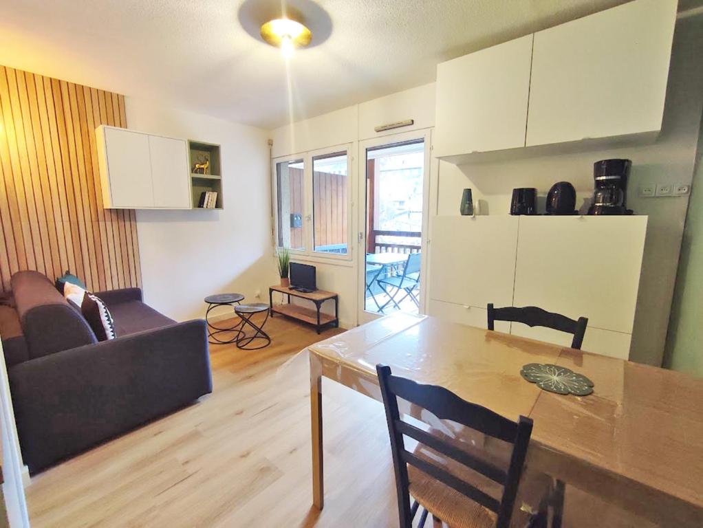 kuchnia i salon ze stołem i kanapą w obiekcie Le cerf charmant, T2, Luchon, wifi, balcon, ascenseur, 4 personnes w mieście Luchon