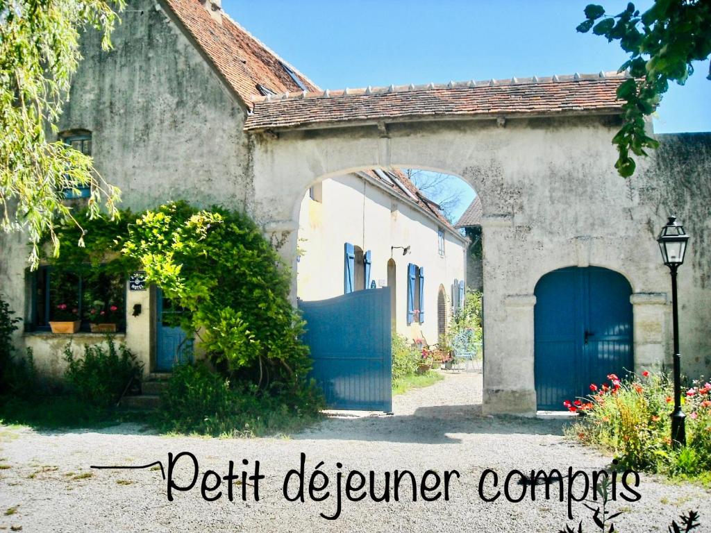 een huis met een blauwe deur en een poort bij Chambres d'Hôtes des Grands Prés in Argentan