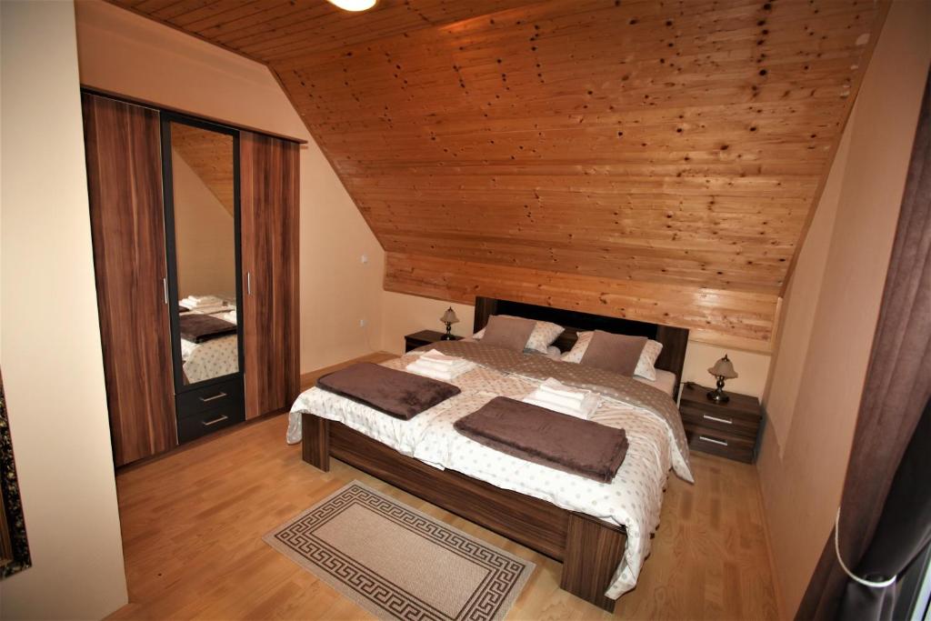 1 dormitorio con cama y techo de madera en Holiday Home Kali, en Hočko Pohorje