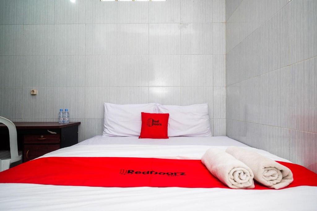 a bed with towels and a red pillow on it at RedDoorz near Danurejan Malioboro in Yogyakarta