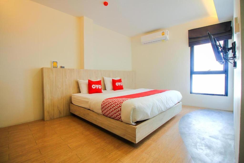 een slaapkamer met een bed met rode kussens erop bij OYO 75416 Rama3 Sunrise Hostel in Bangkok