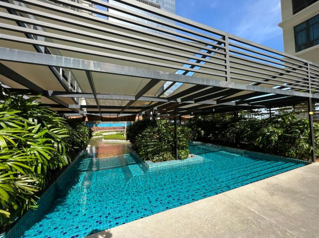 a swimming pool under a bridge in a building at Apartment with 2 Bedrooms, Trefoil @ Setia City (Imperia Asia Guest House) in Shah Alam